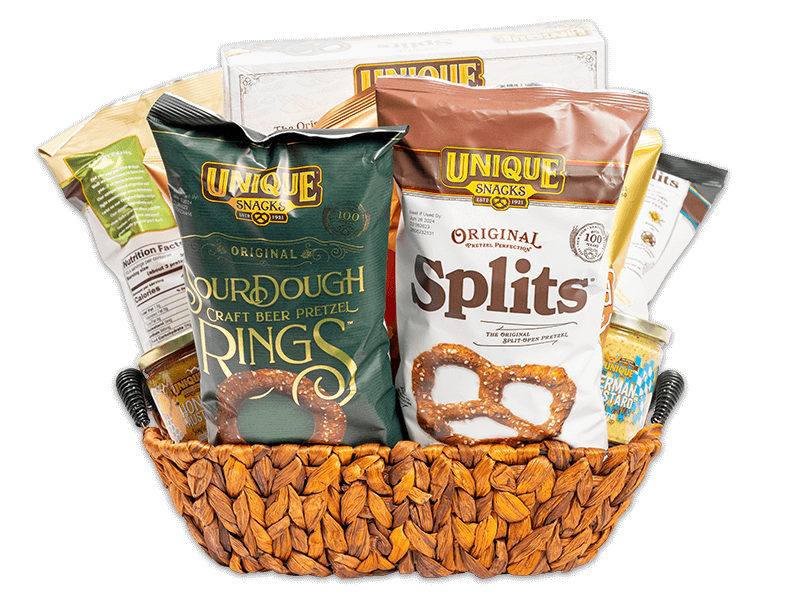 Medium wash woven oblong tray basket with wire handles filled with various Unique Snacks products