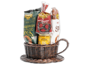 Coffee cup on a plate shaped woven basket filled with various Unique Snacks products
