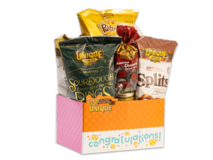 Congratulations basket box, orange, pink, and white sides and polka dots with text "Congratulation" on box filled with various Unique Snacks products