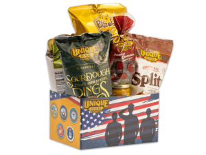 Military basket box with shadows of soldiers saluting in front of an American flag on it, filled with various Unique Snacks products