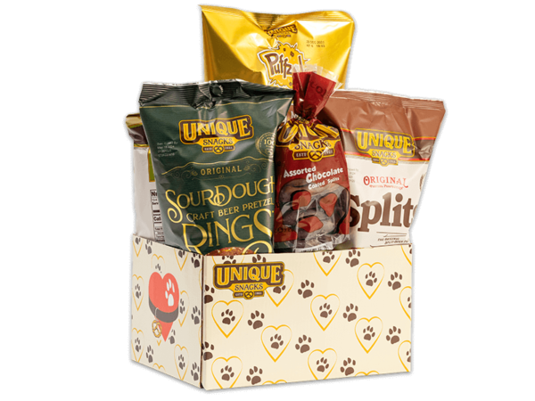 Unique snacks bundle box thats white with yellow hearts and brown paw prints on it, it contains sourdough rings, honey mustard dip, original splits and others