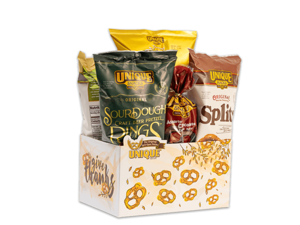 Give thanks basket box, white background with golden pretzel and wheat, text, "give thanks" on box filled with various Unique Snacks products