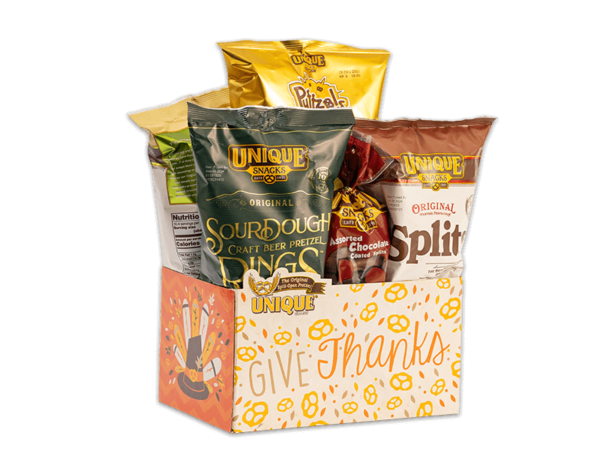 Thanksgiving basket box, pilgrim hat with turkey feathers and text, "Give Thanks" on box filled with various Unique Snacks products