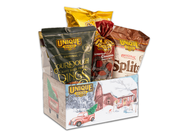 Unique snacks bundle box that has a snow covered barn with a snow man and a red truck in front of it, it contains sourdough rings, honey mustard dip, original splits and others