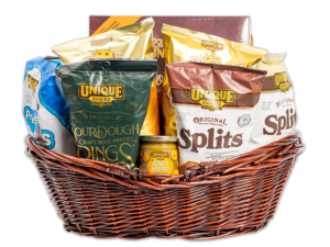 varied unique snacks products in a large dark redish washed woven basket