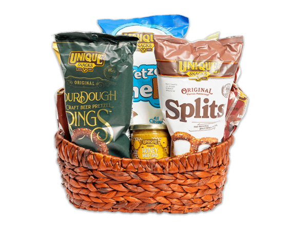 Medium sized light washed woven basket filled with various Unique Snacks products