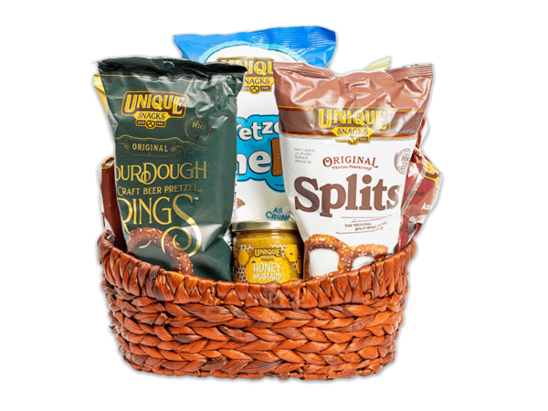 Medium sized light washed woven basket filled with various Unique Snacks products