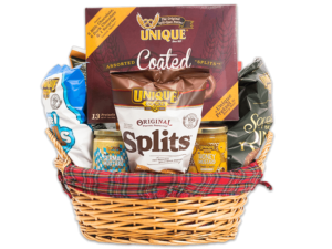 Red Plaid liner woven gift basket with a plaid clothes tied to the top filled with various Unique Snacks products