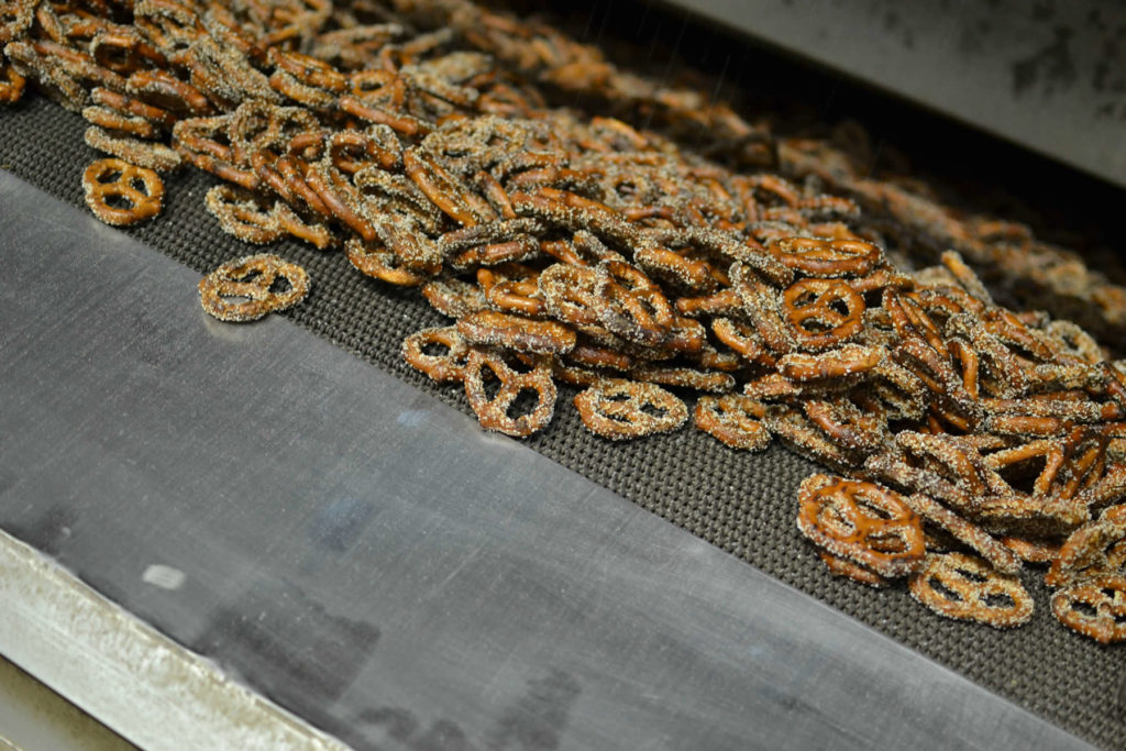An oven conveyor belt filled with Pretzel Splits