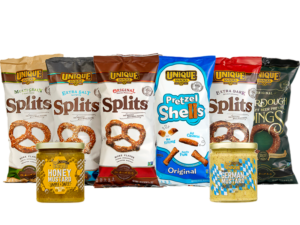 Unique snacks pretzel shells in a blue and white bag, multigrain pretzel splits in tan and white bag, extra salt pretzels in black and white bag, original pretzel splits in brown and white bag, extra dark pretzel splits in red and white bag, sourdough rings in green bag, honey mustard dip in a jar with honey comb packaging, german mustard dip with white and blue packaging