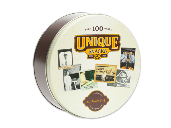 a brown tin with a cream colored lid that has over 100 years written in brown and the unique snacks logo, as well as pictures of the workers at unique snacks over the years and a brown logo at the bottom with white and yellow writing in cursive and small print