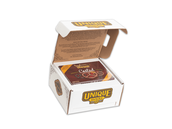 Chocolate box topper has a box of coated pretzels inside a white box with the unique snacks logo on it